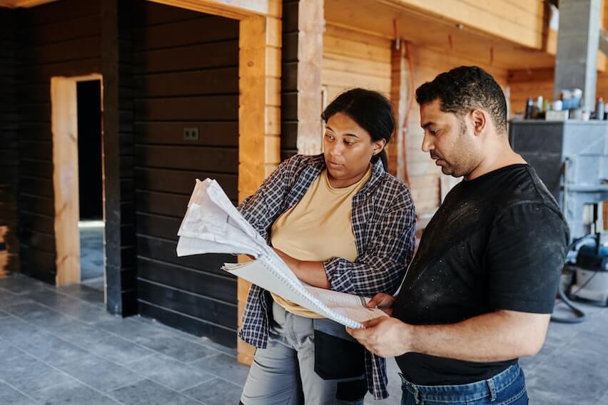 2 workers renovating a house reviewing project planning elements